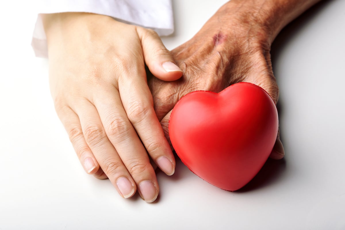 Young Doctor Holding Senior Patient's Hand to Help and Support