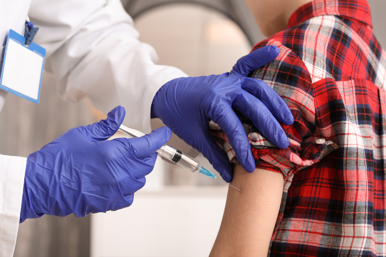 Doctor Vaccinating Child against Flu in Clinic